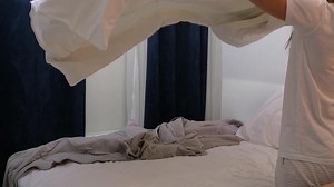 morning routines. young woman wearing pajamas making bed in the morning